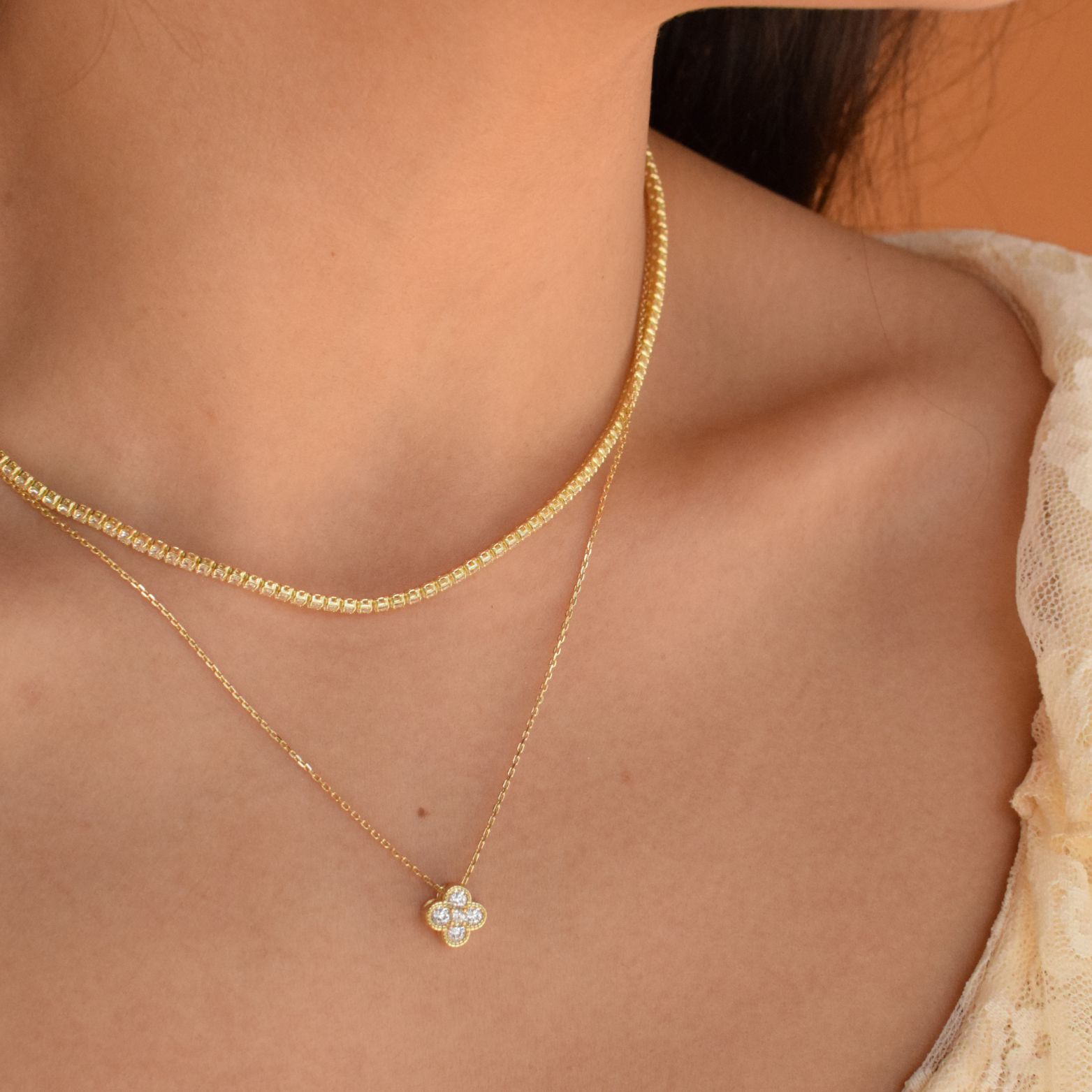 Close-up of a woman showcasing the 14K gold plated clover necklace