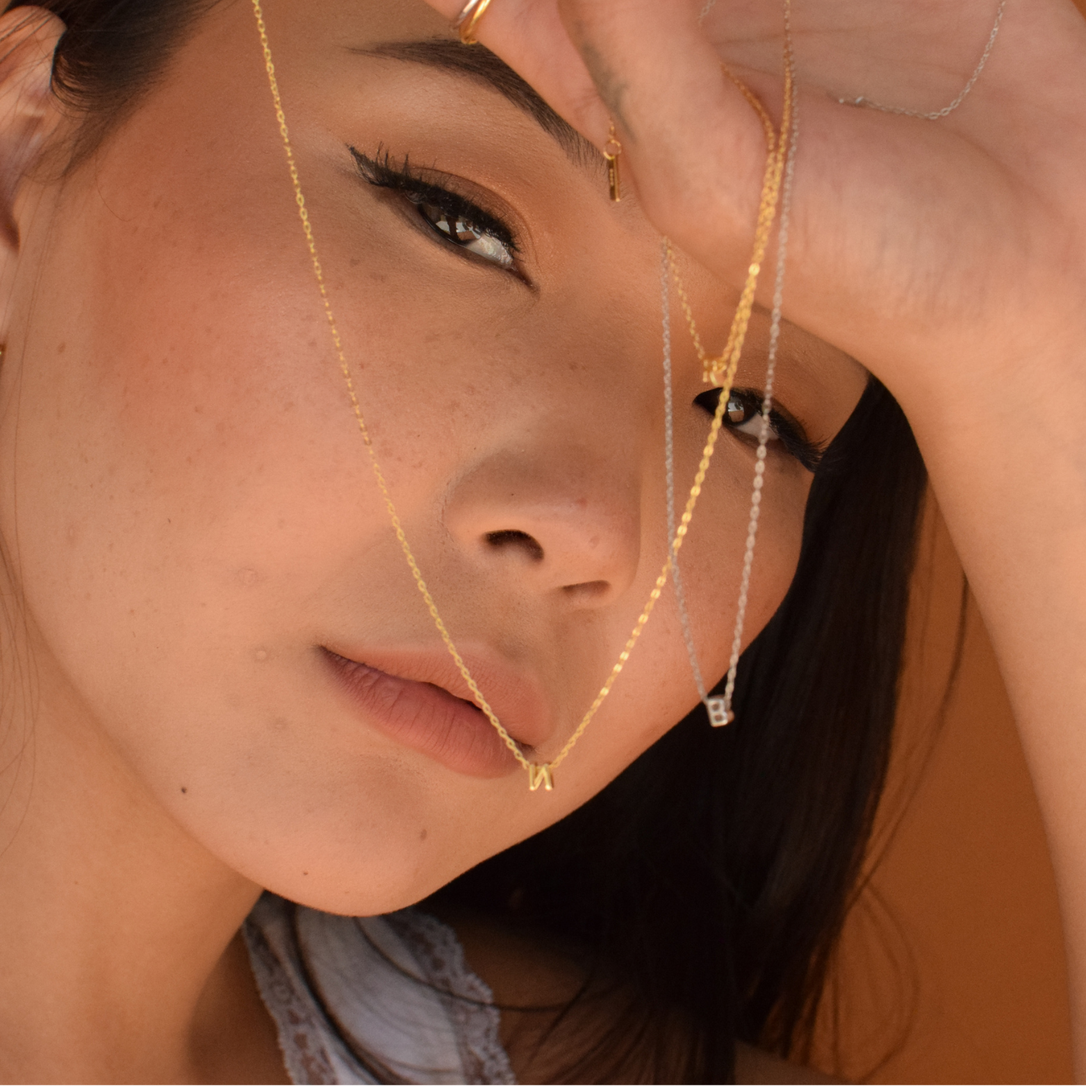 Portrait of a woman wearing a 14k vermeil initial necklace