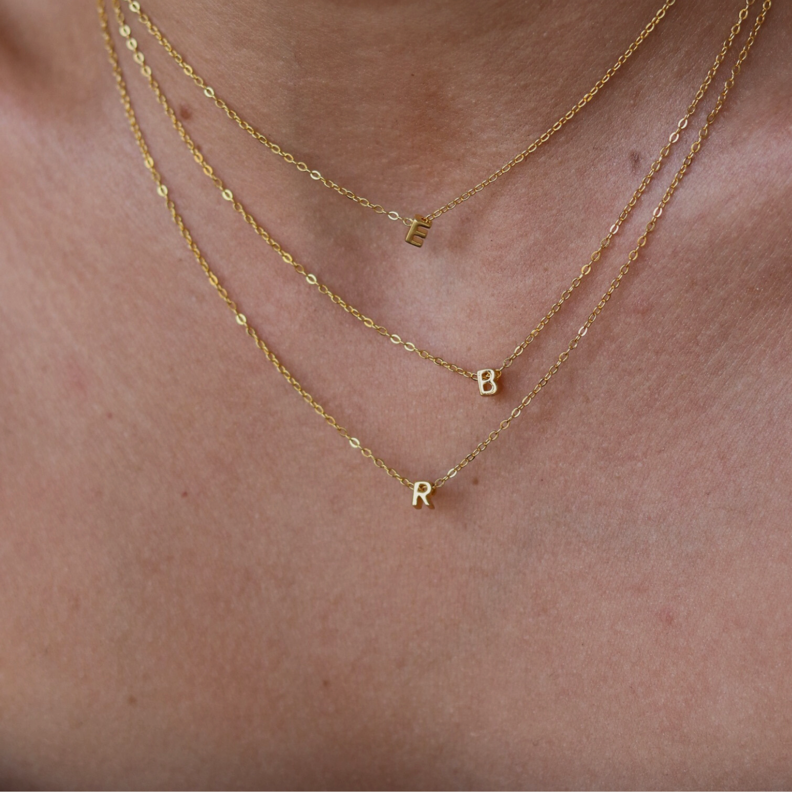 Close view of a 14k vermeil initial necklace on a delicate chain