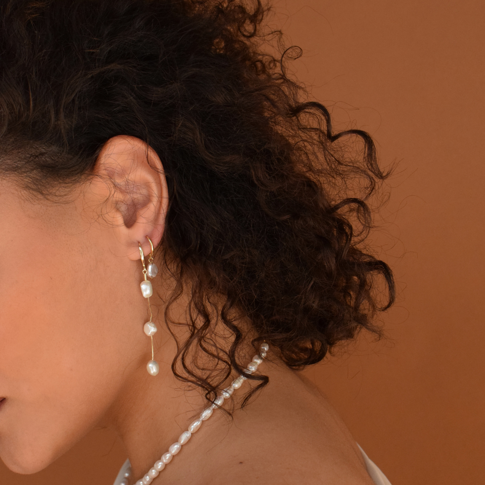 Profile view of a woman wearing the 14K Gold Plated Baroque Hoops