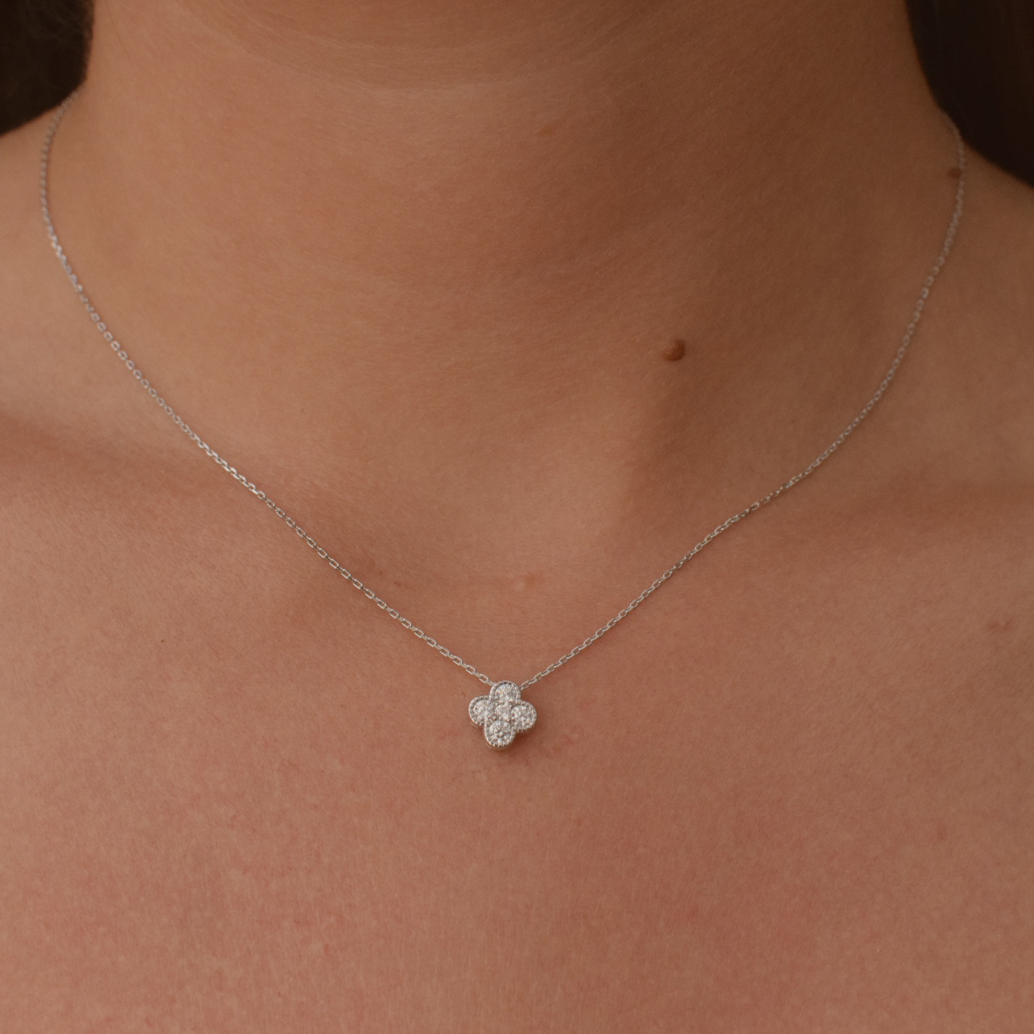 Close-up of a woman wearing a sterling silver clover necklace