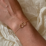 Close-up of a 14K gold-plated interlock bracelet on a woman's wrist