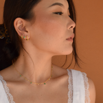 Model showcasing Green Logan Hoops - 14K Gold Plated earrings with a white blouse