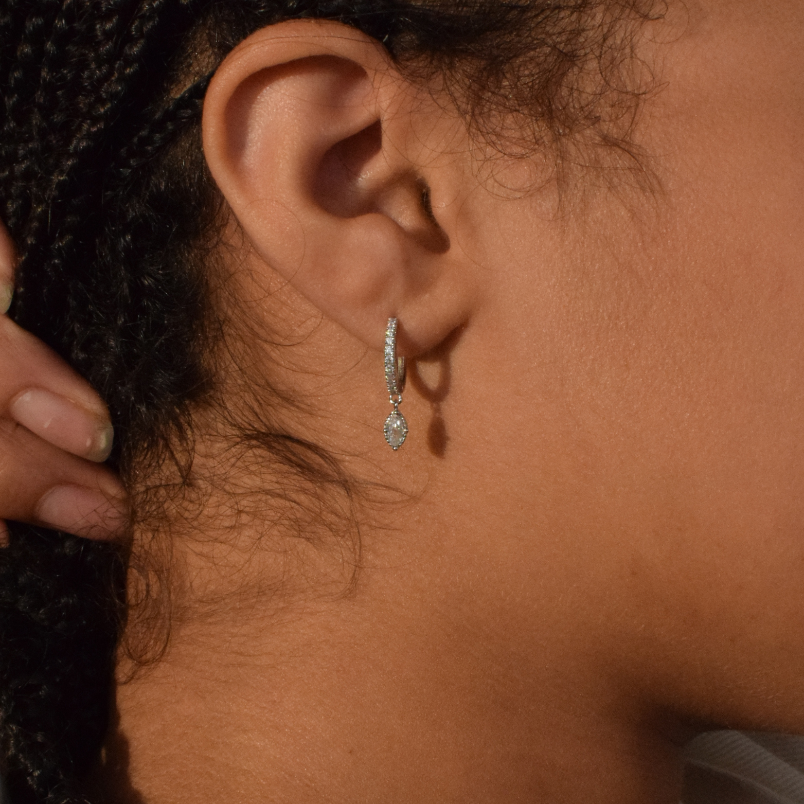 Close-up of a woman wearing the Lola sterling silver hoop earrings