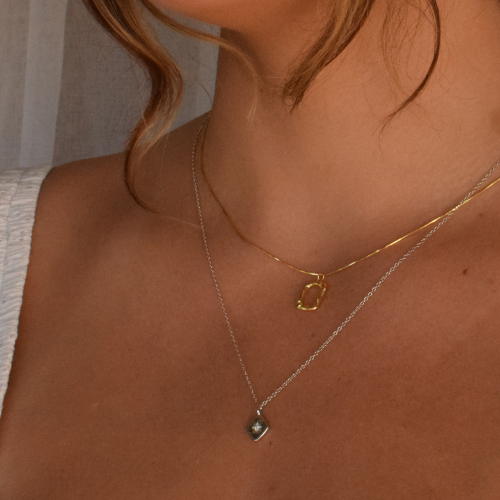 A woman showcasing the Altair Necklace made of sterling silver