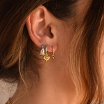 Close-up of two-tone heart hoop earrings on a display