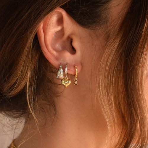 Close-up of two-tone heart hoop earrings on a display