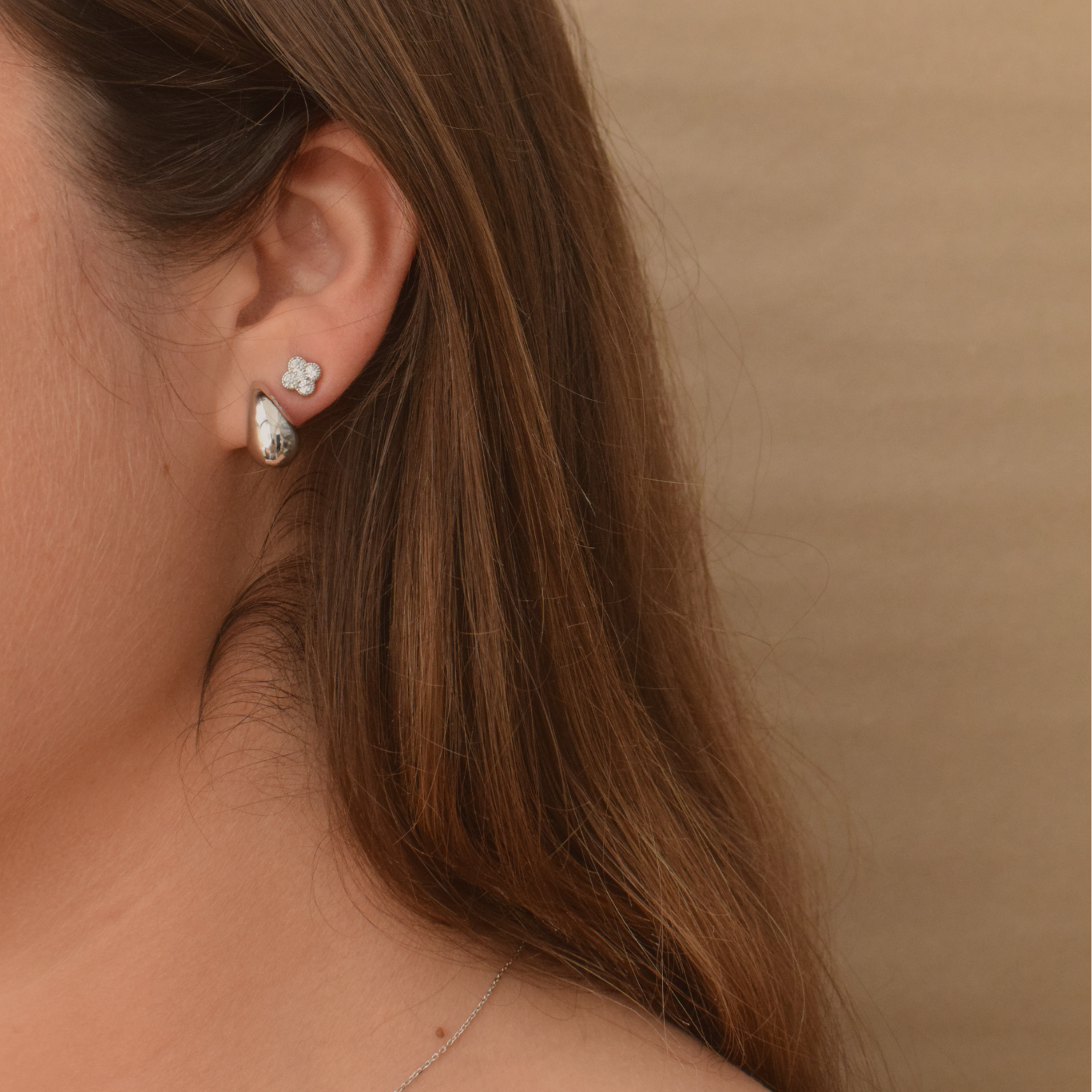 Side view of a woman wearing sterling silver clover stud earrings