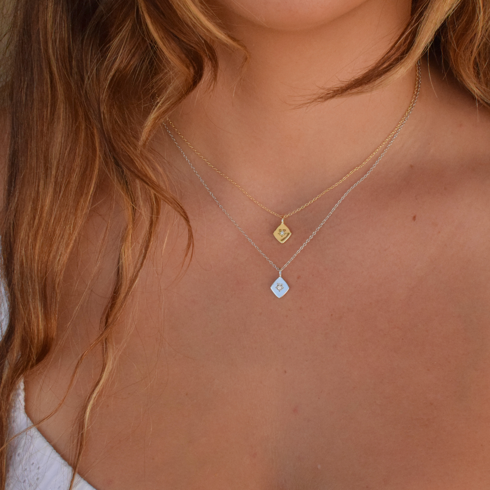 A person showcasing the Altair necklace featuring 14K gold plating and a delicate design