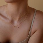 Woman showcasing her Petite Initial Necklace made of 14K solid gold
