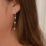Side view of a woman modeling the Jasmine Studs 14K gold plated earrings
