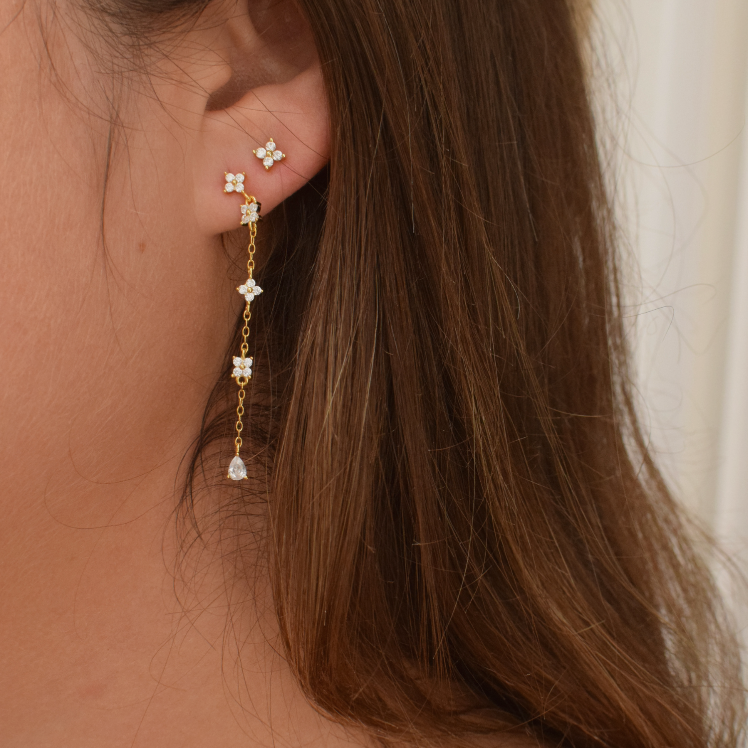 Side view of a woman modeling the Jasmine Studs 14K gold plated earrings