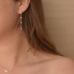 Close-up of a woman's ear adorned with Starburst Stud earrings in 14K gold plating