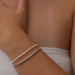 A lifestyle shot of a woman wearing a sterling silver tennis bracelet with round stones
