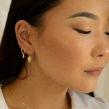 Portrait of a woman in a white blouse showcasing her Grace Hoops earrings