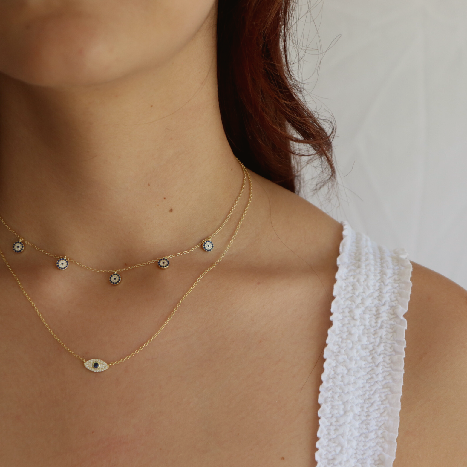 Detail shot of the Iris Necklace's evil eye pendant in 14K gold plating