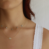 Woman showcasing the Zephyr necklace with its 14K gold plating